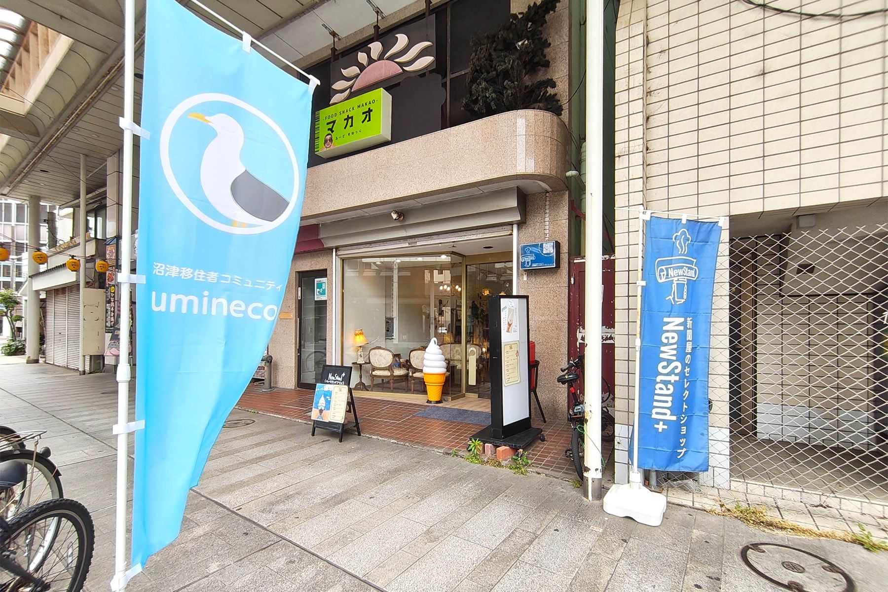 店頭の写真 お店の前でうみねこのロゴが印刷されたのぼりがはためいている