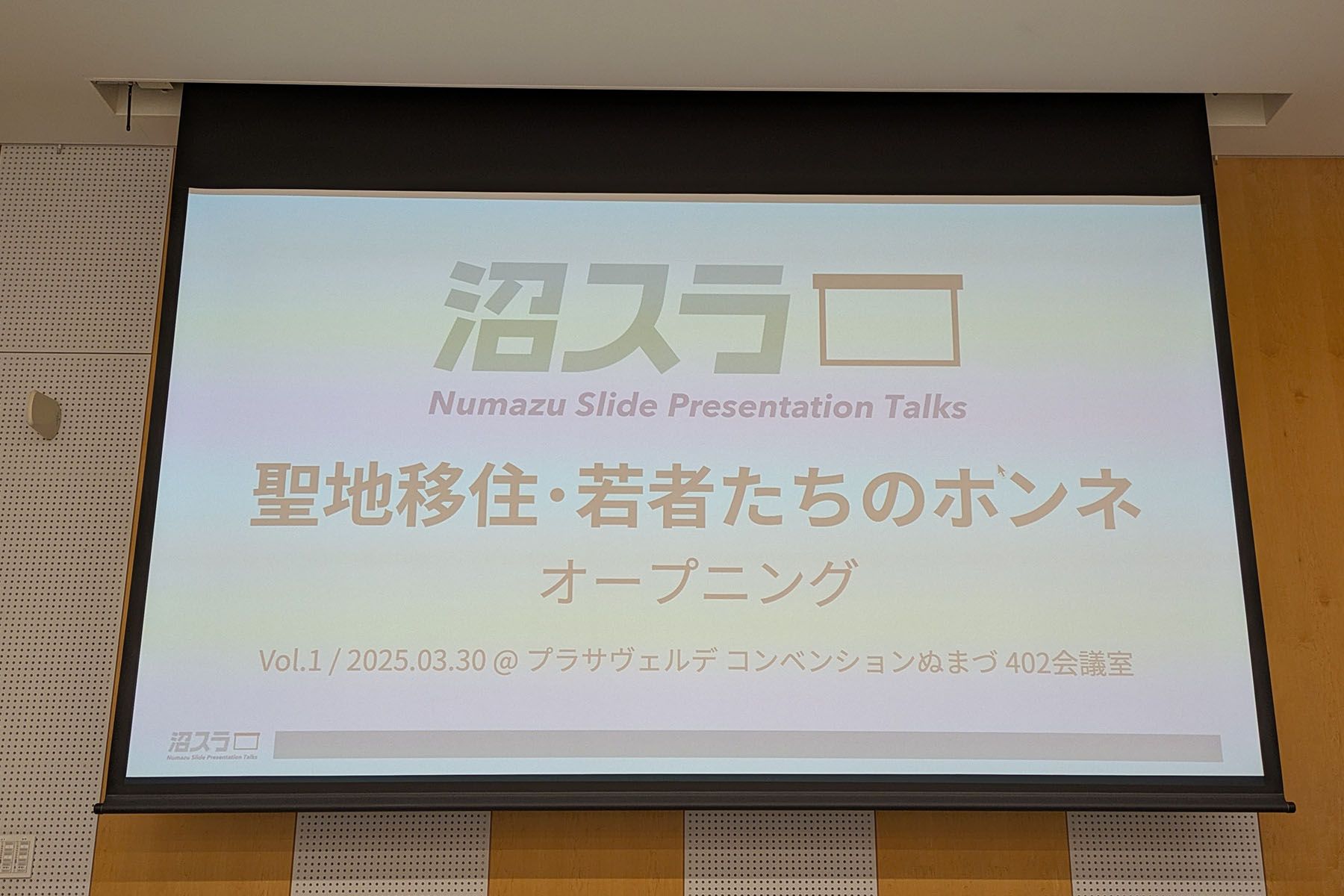 「沼スラ」のロゴと今回のタイトル「聖地移住・若者たちのホンネ」という文字が映し出されたスクリーンの写真。
