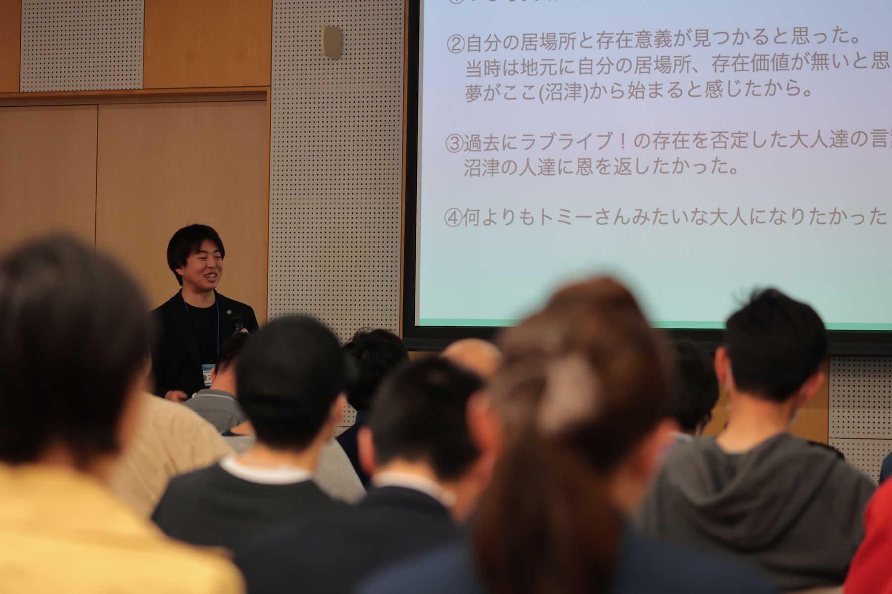 プレゼン発表する人の様子を聴衆越しに撮影している。