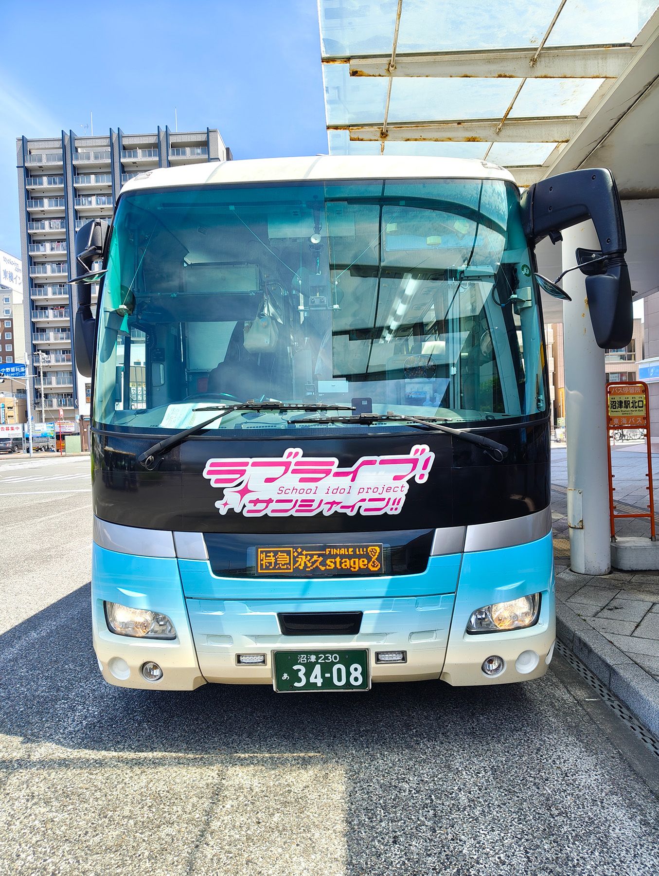 沼津駅北口に停車中のラッピングバスを正面から。方向幕(LED)の部分は、LED表示風の手作りのボードが貼り付けてある。